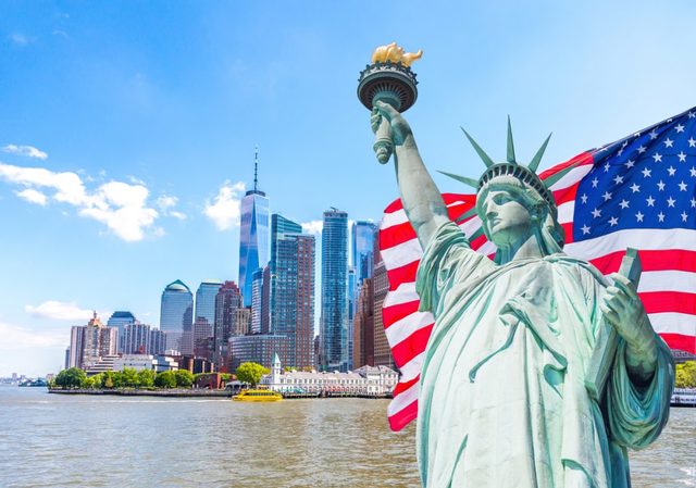 Statue-of-Liberty-with-large-american-flag-in-the- Abogado De Inmigracion Bronx